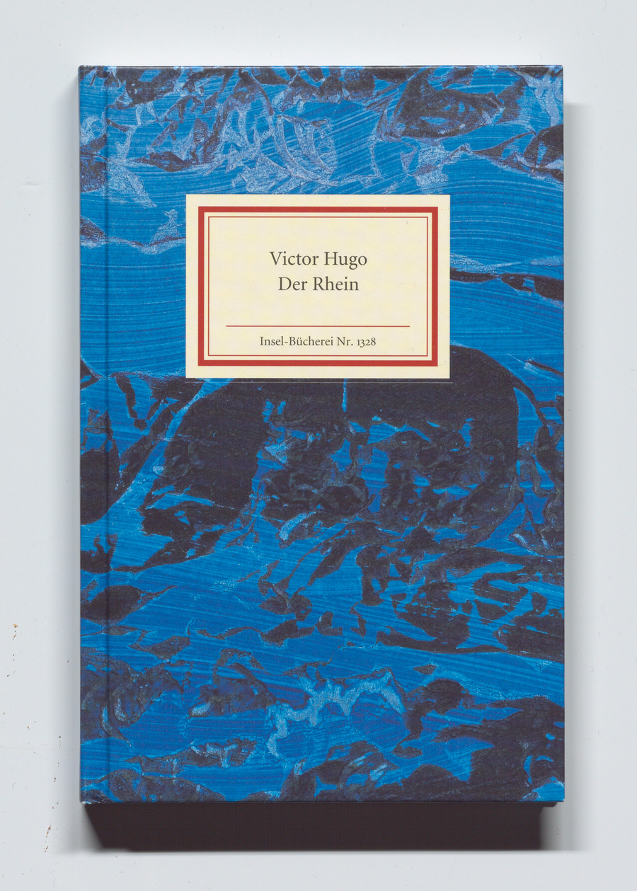 Buchcover von ‚Victor Hugo: Der Rhein‘, Insel-Bücherei Nr. 1328, mit abstraktem Design in Blau- und Schwarztönen und einem cremefarbenen Label mit roter und goldener Umrandung.