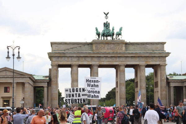 Protest vor dem Brandenburger Tor in Berlin mit Plakaten gegen Corona-Maßnahmen.