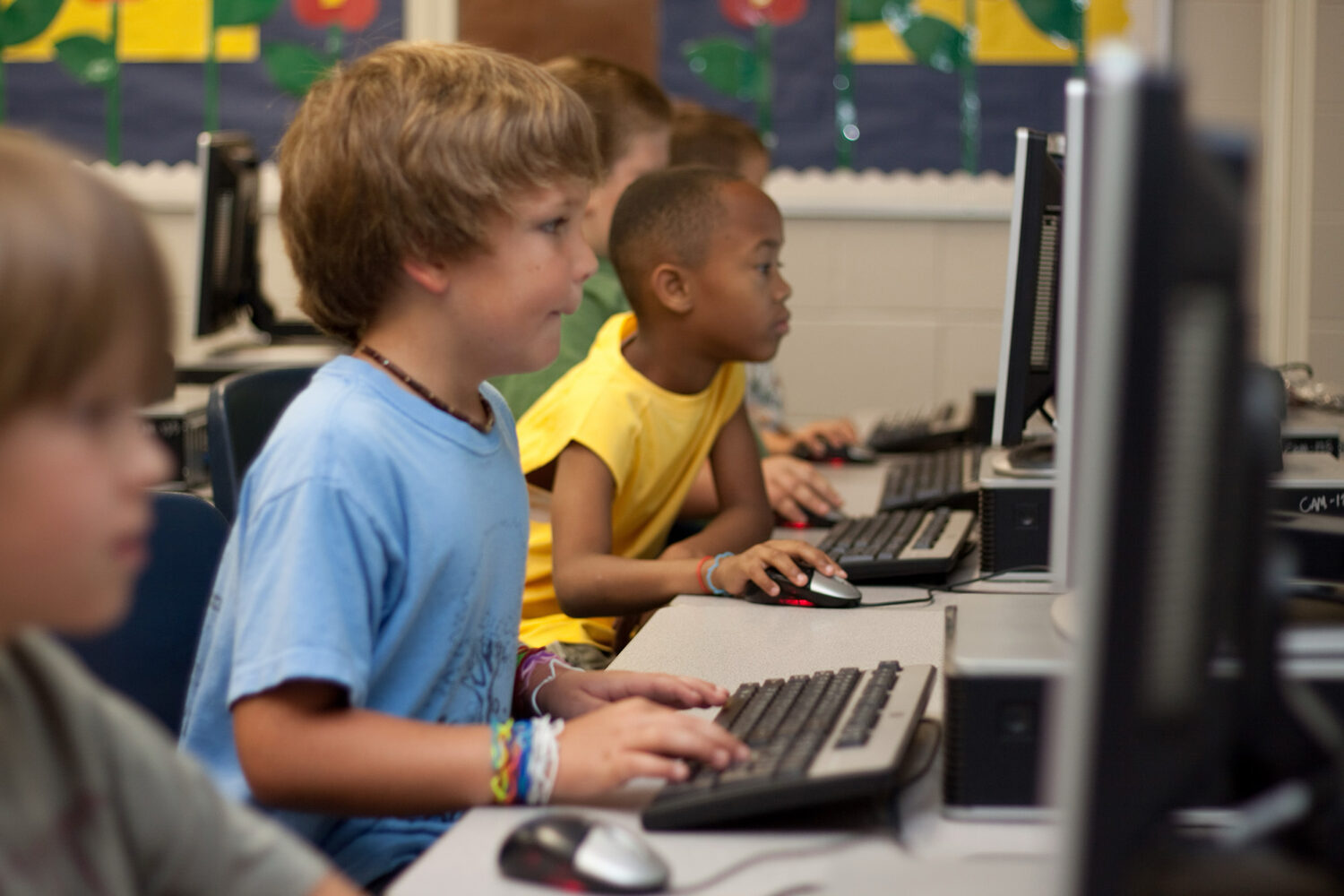 Kinder arbeiten konzentriert an Computern in einem Klassenzimmer.