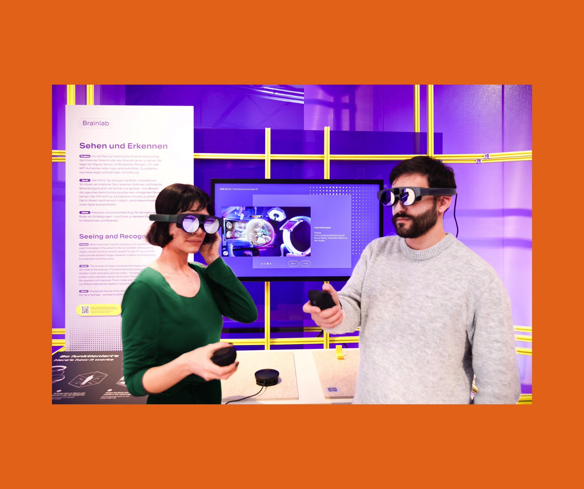 Zwei Personen tragen VR-Brillen und halten Controller in einem Raum mit lila Beleuchtung und einem Bildschirm.
