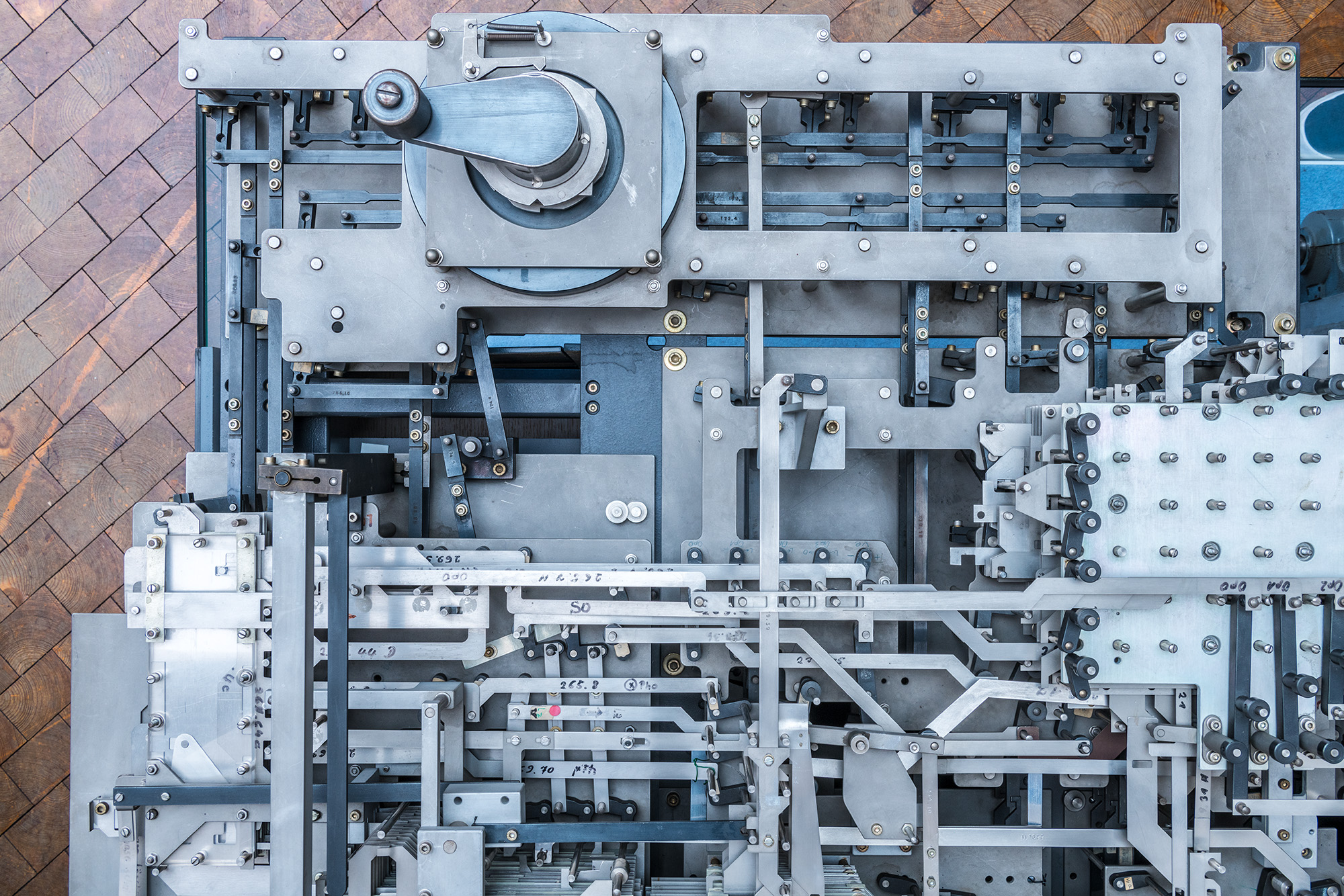Sicht von oben auf einen Teil des Rechenwerks des Nachbaus des Z1-Computers mit komplexen mechanischen Komponenten und einer Handkurbel.