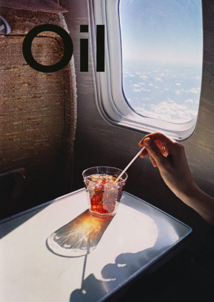 Hand hält Strohhalm in einem Glas mit rotem Getränk im Flugzeug, während aus dem Fenster Wolken zu sehen sind und das Wort "Oil" groß im Vordergrund steht.