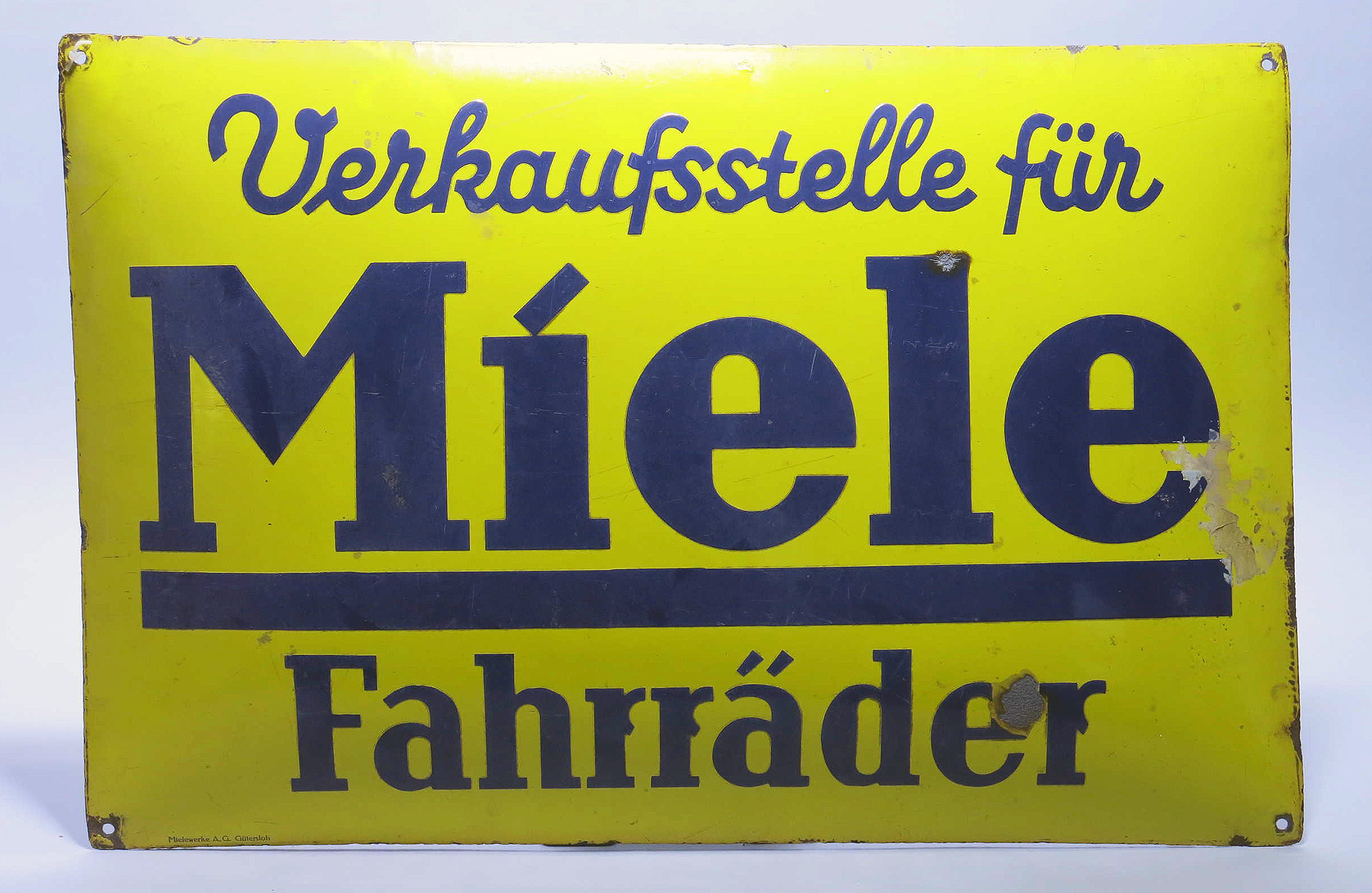 Gelbes Werbeschild mit der Aufschrift ‚Verkaufsstelle für Miele Fahrräder‘.